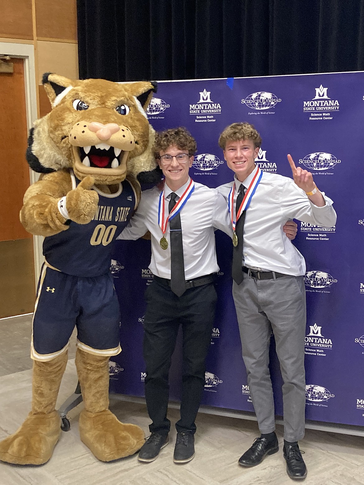 Ethan Amick and Jake Dunker with Champ. Dunker and Amick won gold medals for the Microbe Mission event. (Photo provided by Tait Rocksund)