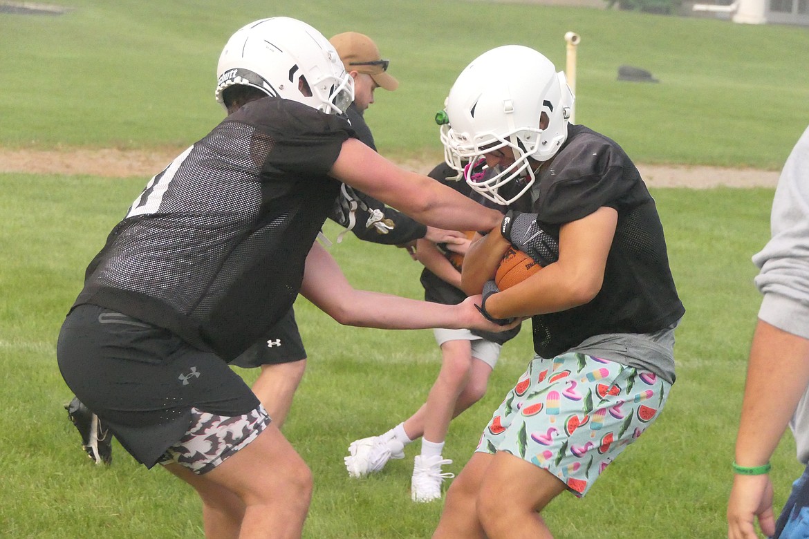 St. Regis running back Kaden Sanders (left) and Ayden Rael run a drill on holding onto the football during the Tigers' opening practice this past week. (Chuck Bandel/VP-MI)