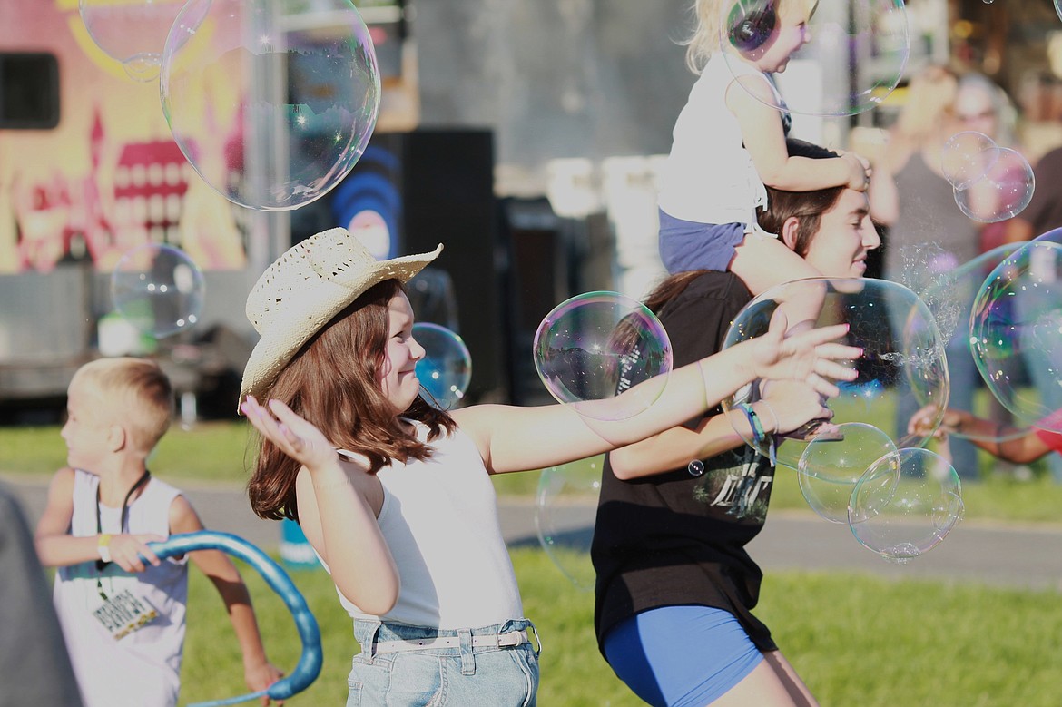 Children pop oversized bubbles created by the Bubbler at the Grant County Fair on Aug. 14.