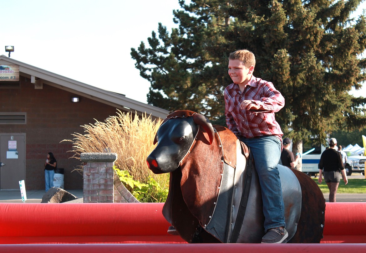 Chase Burke rides the bull on August 14 at the Grant County Fair. It was $5 to attempt to ride the bull and Burke stayed on for over a minute before being bucked off.