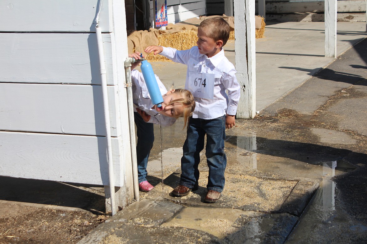 A Grant County Fair competitor grabs a quick drink.