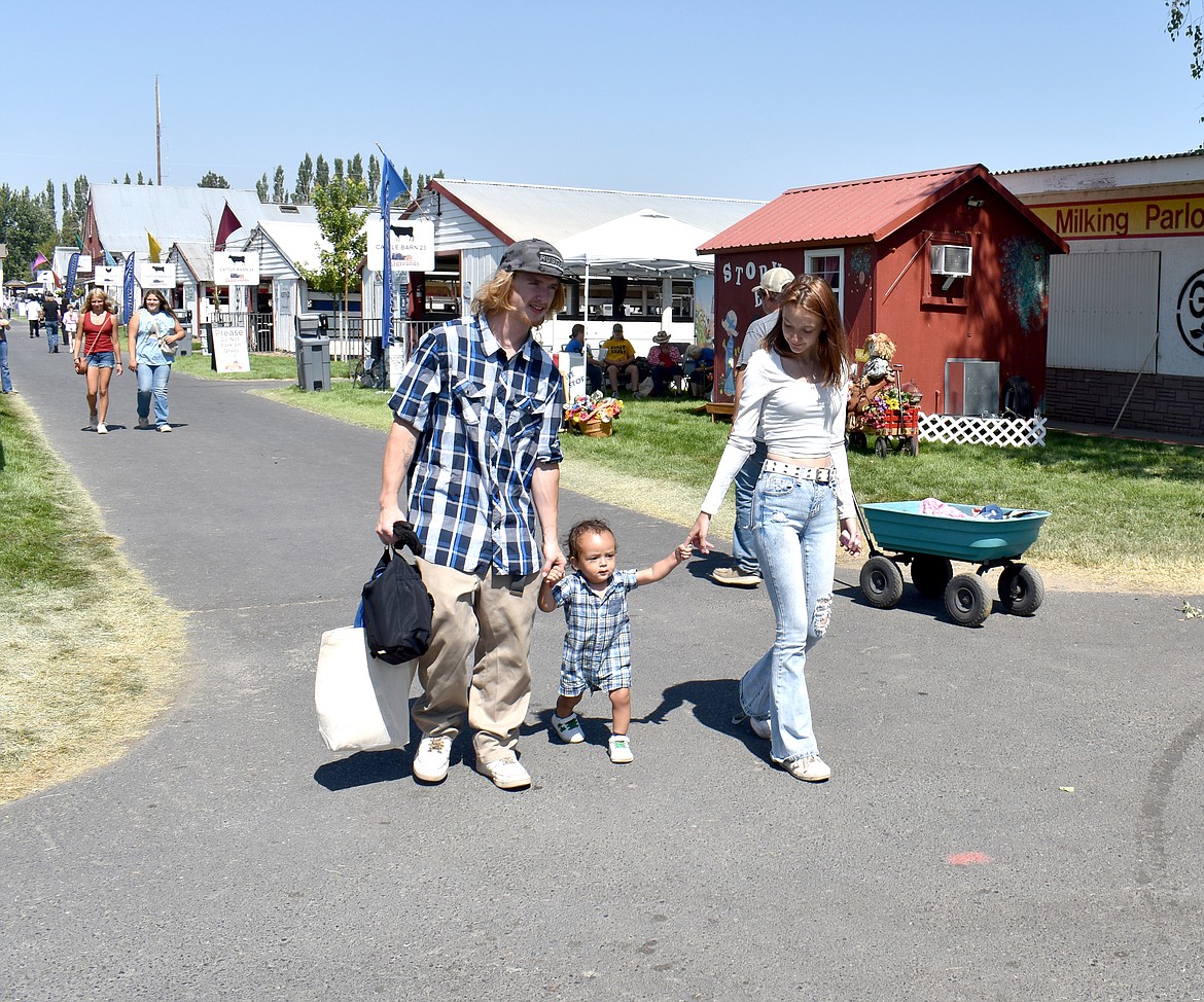 A family walks down Yarbro Avenue at the Grant County Fair on Aug. 14.