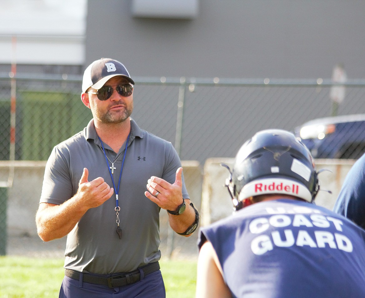 (left) BFHS head football coach Danny Swift instructs the offensive line through a play.