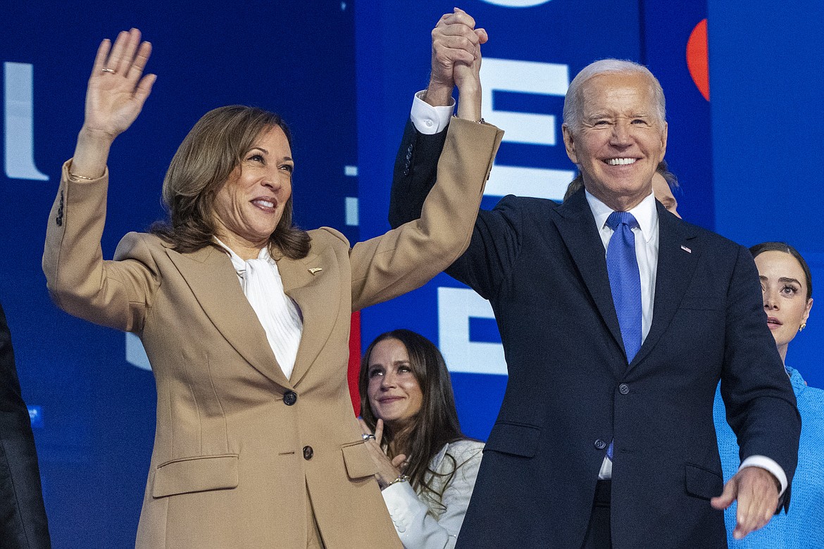 Democratic presidential nominee Vice President Kamala Harris, left, clasps her hand in the air with President Joe Biden at the Democratic National Convention, Monday, Aug. 19, 2024, in Chicago. (AP Photo/Jacquelyn Martin)