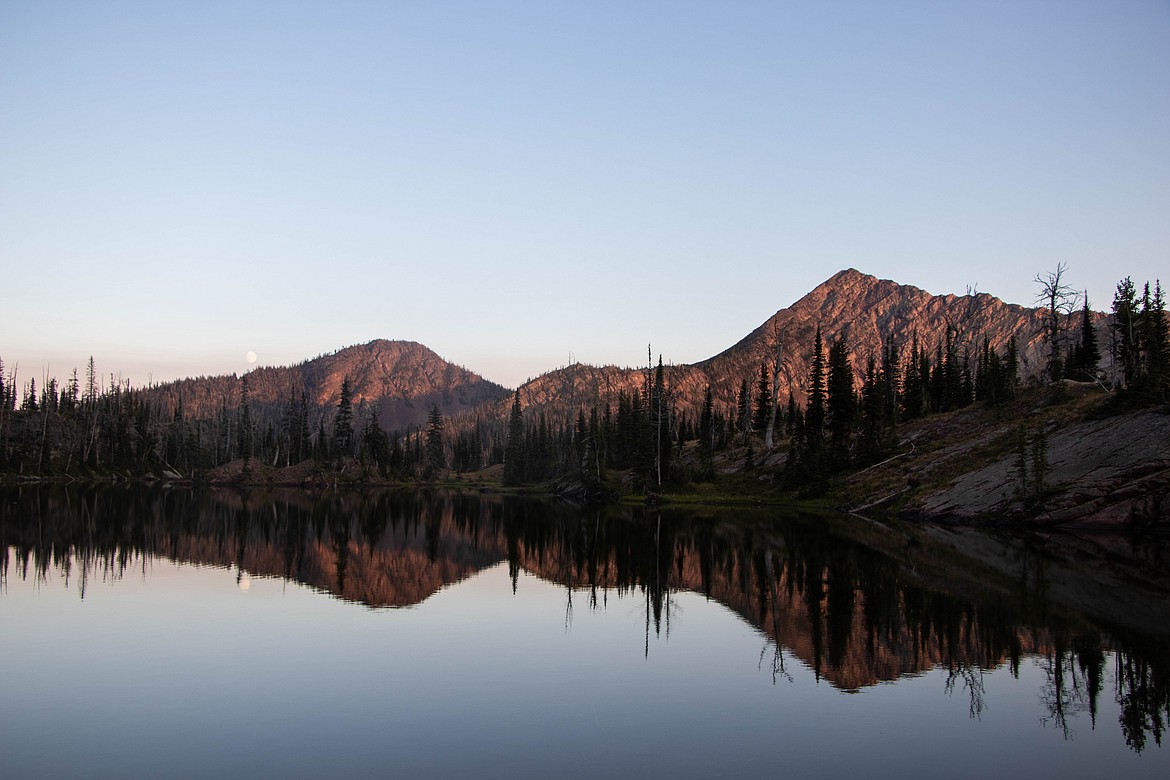 The moon rises as the sun sets over an alpine lake in the Swan Range. (Kate Heston/Daily Inter Lake)