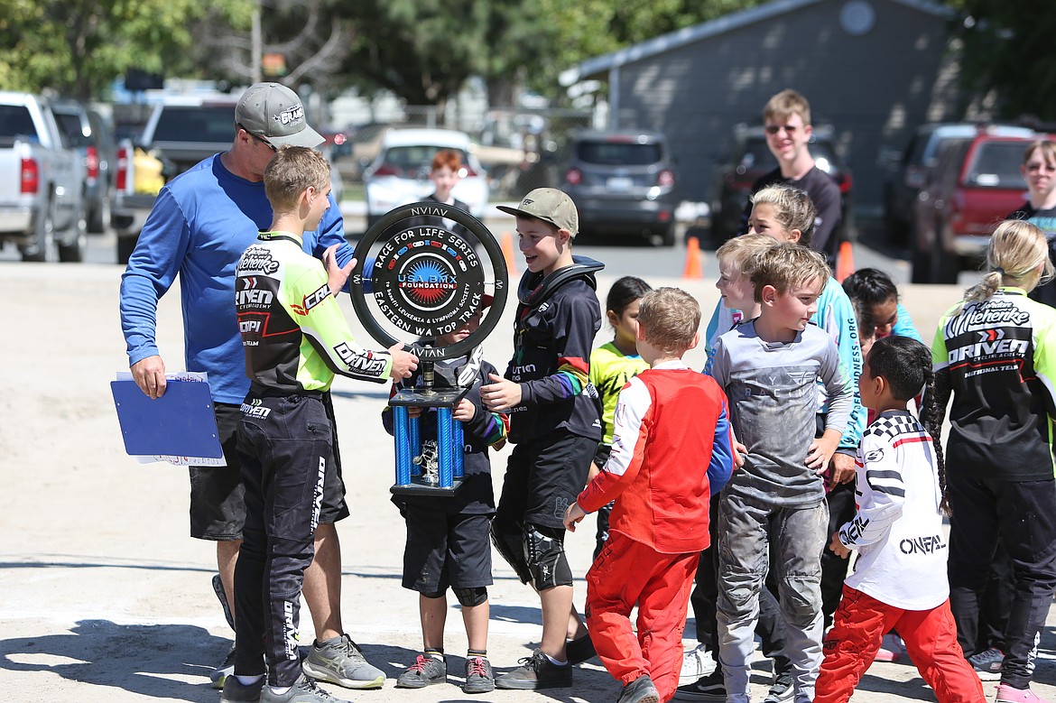 Riders in Moses Lake BMX celebrate with the trophy for raising the most money in the Eastern Washington Race for Life Series.