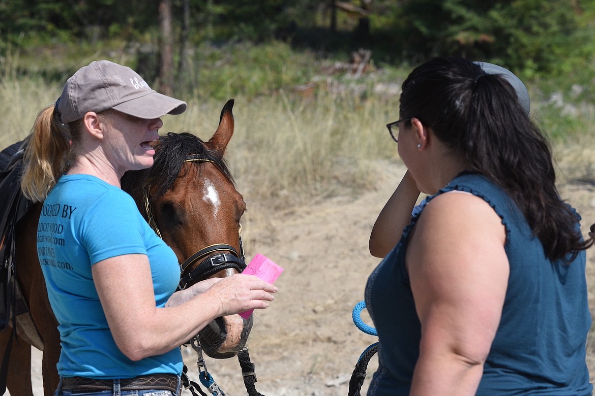 Big Sky Memorial Ride co-organizer Shayne Russell, left, talks with volunteer Veronica Lee at the Big Sky Memorial Ride Saturday, Aug. 10, 2024. (Scott Shindledecker/The Western News)