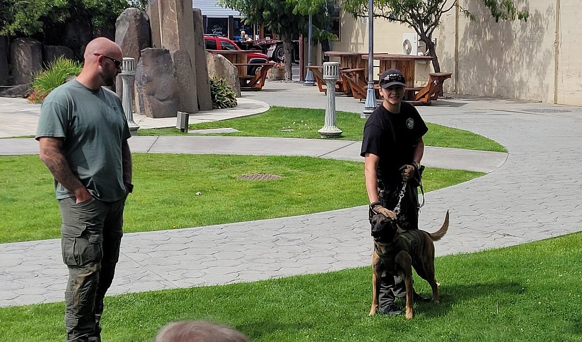 K-9 Handler, Deputy Zane Bundy talks with a group of residents about his relationship with his canine partner, Mallie, during a Wednesday afternoon gathering while Moses Lake Police Department K-9 Handler, Officer Nick Stewart stands nearby.