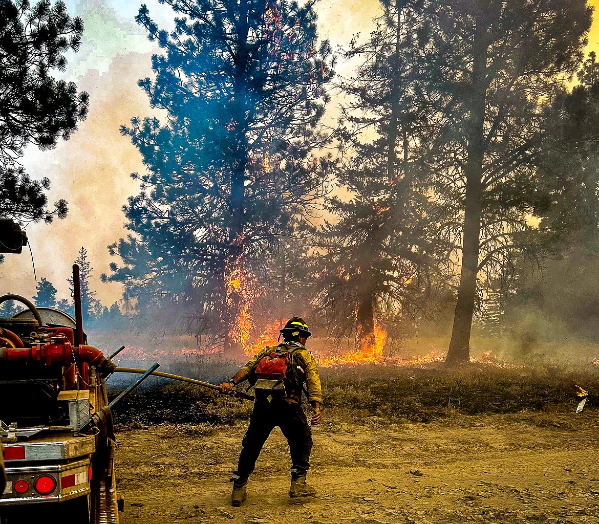 A firefighter works to battle the Retreat Fire southeast of Naches. The fire is the largest currently burning in Washington state.