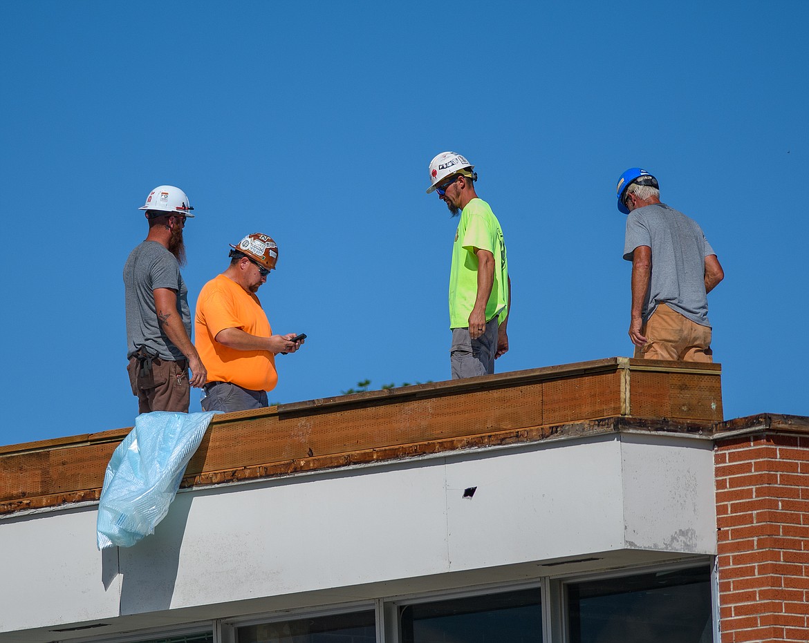 Crews work on the roof of the Columbia Falls High School on Aug. 19. (Chris Peterson/Hungry Horse News)