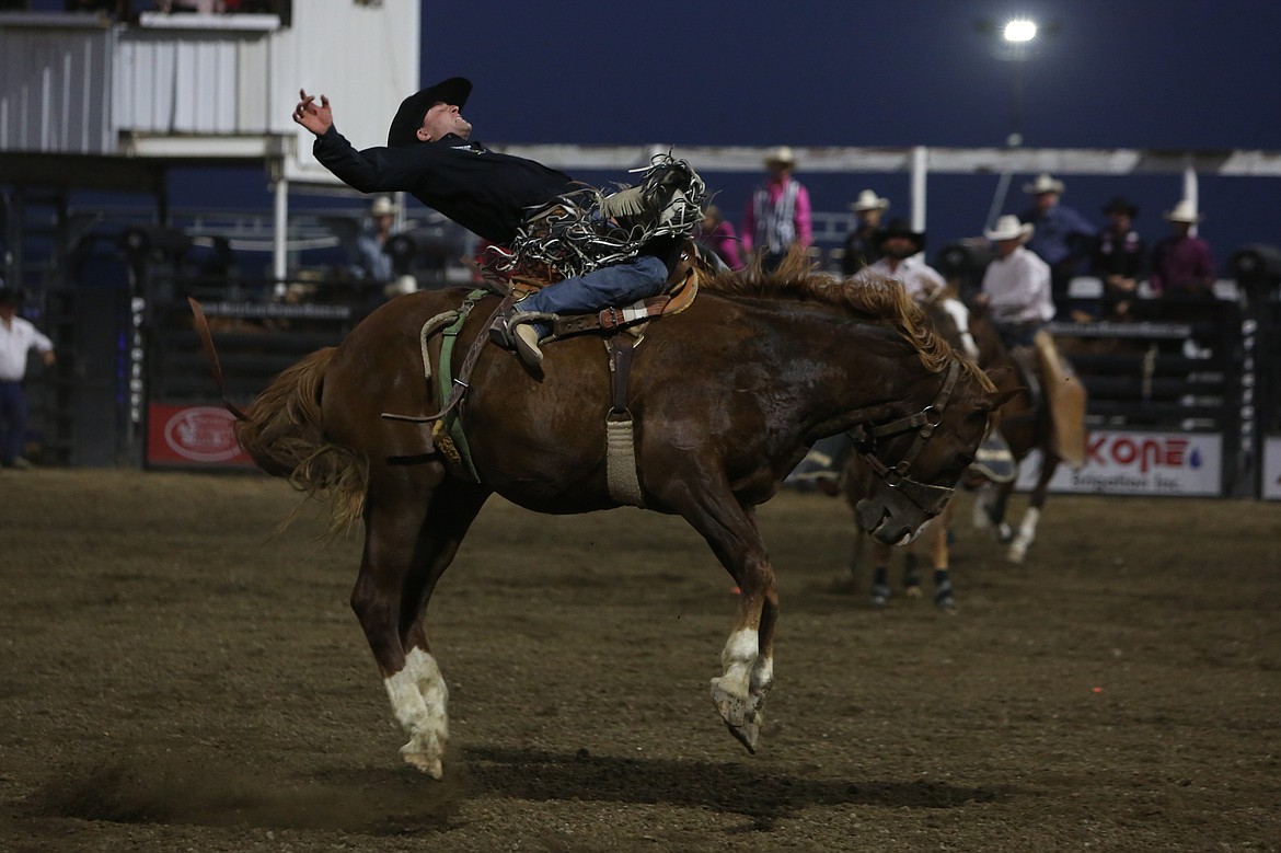 Saddle bronc rider Brody Wells keeps his balance atop the horse at the August 15 performance of the Moses Lake Roundup.