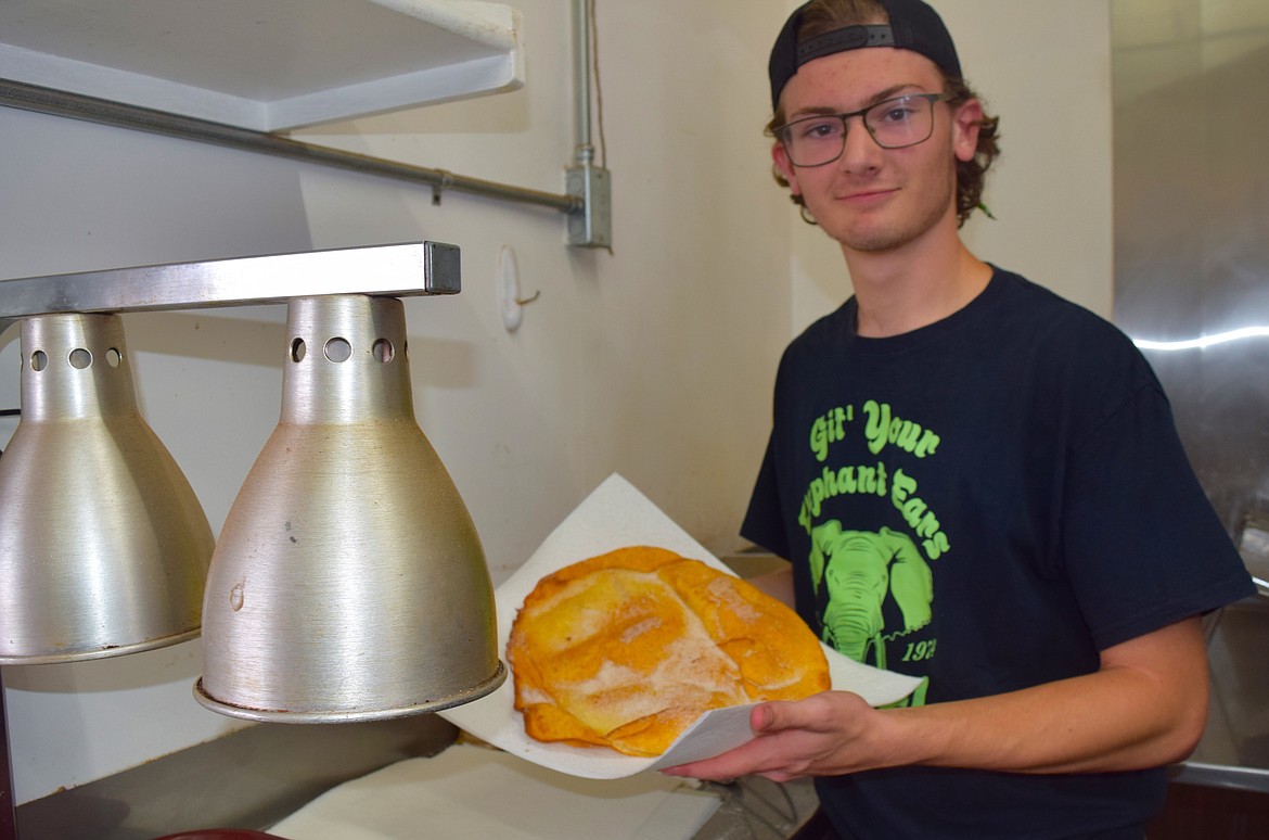 Nathan Mayne shows off the finished product: a hot and fresh elephant ear dusted with cinnamon sugar.