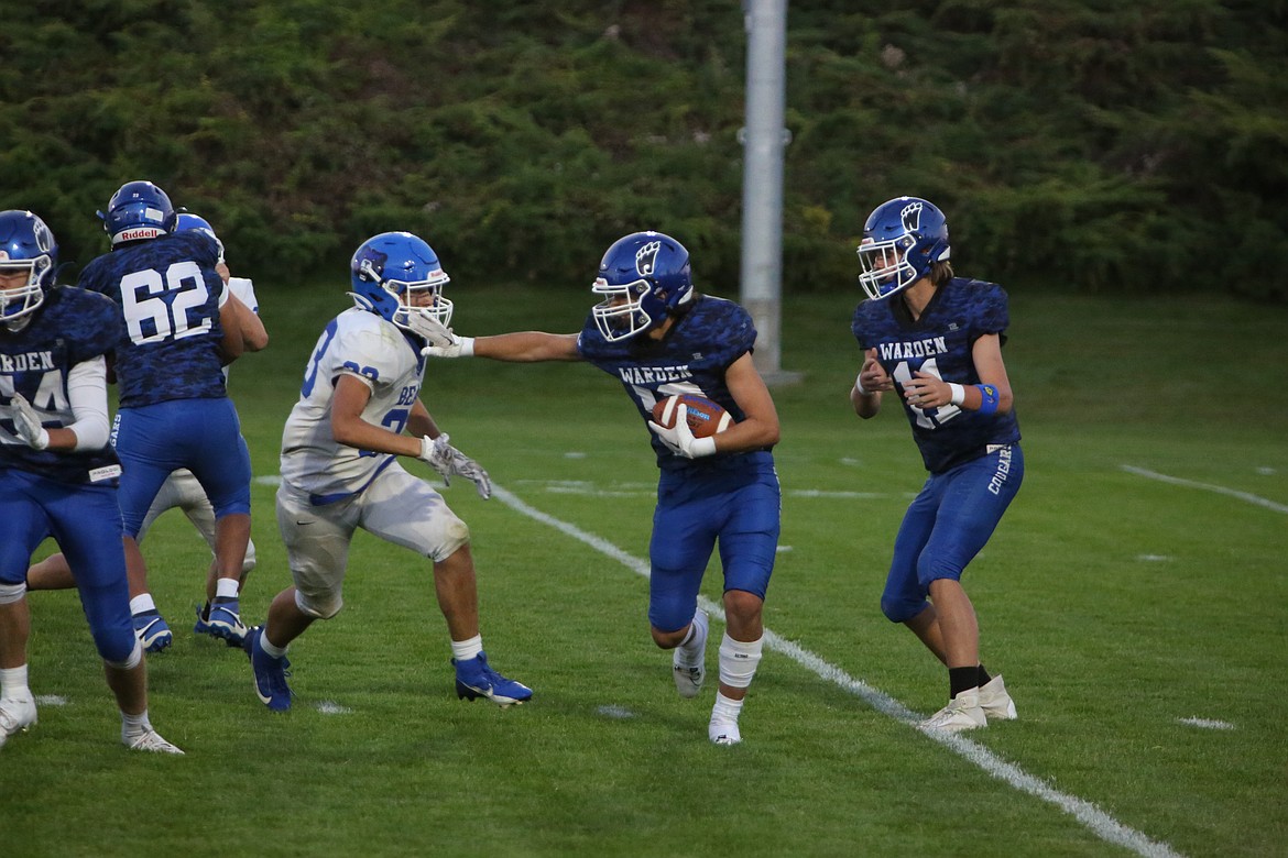 A Warden running back stiff-arms a Kiona-Benton defender during a game last fall. The Cougars are seeking to improve off of last season’s 4-6 campaign.