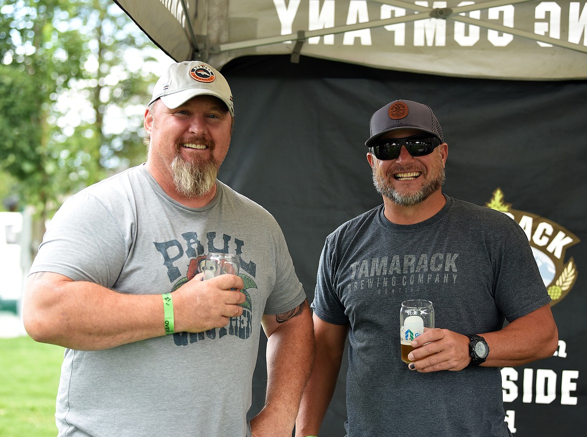 Jeremy Hageness enjoys a beer and a laugh with Tamarack Brewing Company's Colby Shaw at the S.N.O.W. Bus Brewfest. (Julie Engler/Whitefish Pilot)