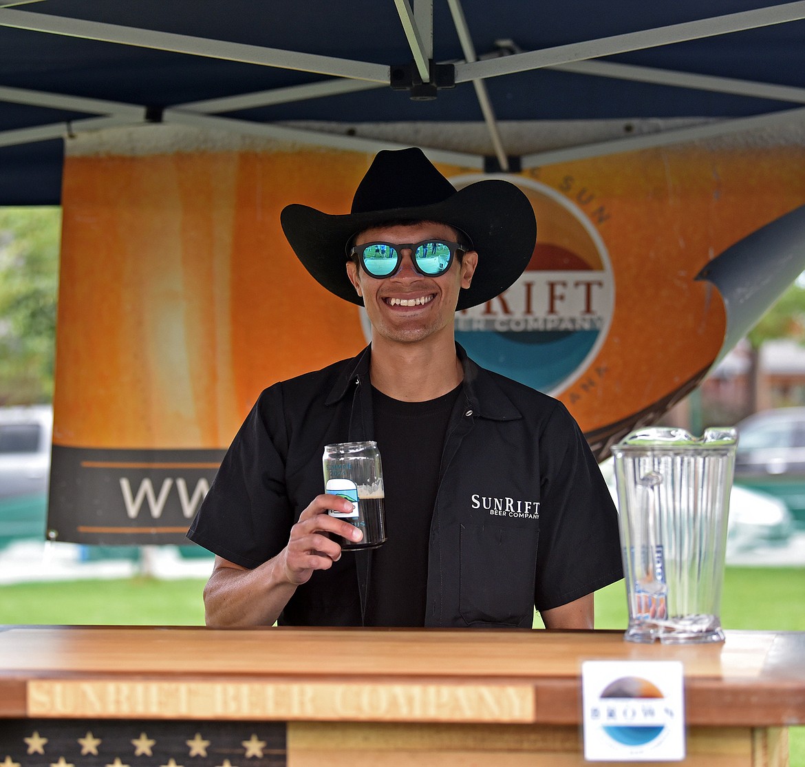 Nathan Clever manned the SunRift Beer Company booth at the S.N.O.W. Bus Summer Brewfest Saturday. (Julie Engler/Whitefish Pilot)