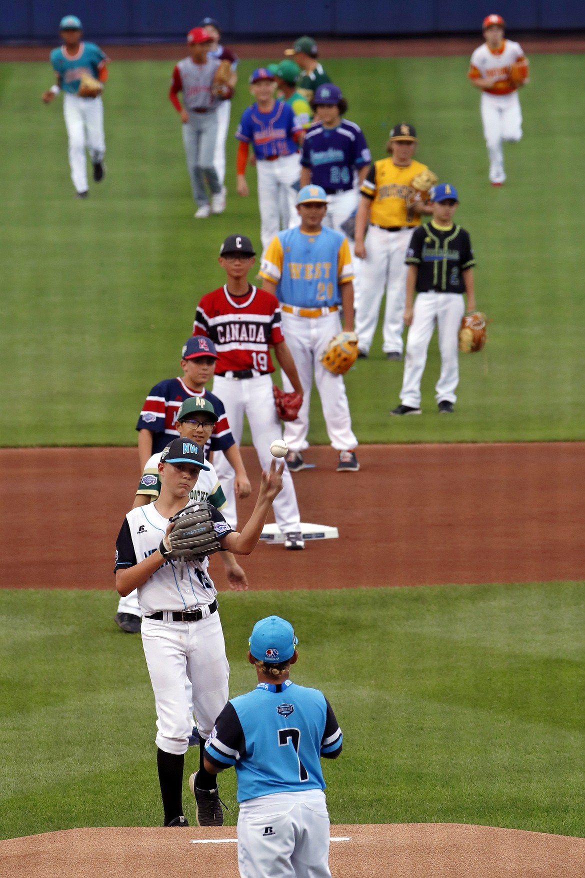 GENE J. PUSKAR/Associated Press
Coeur d’Alene’s Austin DeBoer, second from bottom, tosses the ball to Panama’s Carlos Arcia (7) to complete the ceremonial first pitch involving a member of each Little League team participating in the Little League World Series tournament, before the Little League Classic baseball game between the Philadelphia Phillies and the New York Mets at Bowman Field in Williamsport, Pa., on Sunday, Aug. 19, 2018.