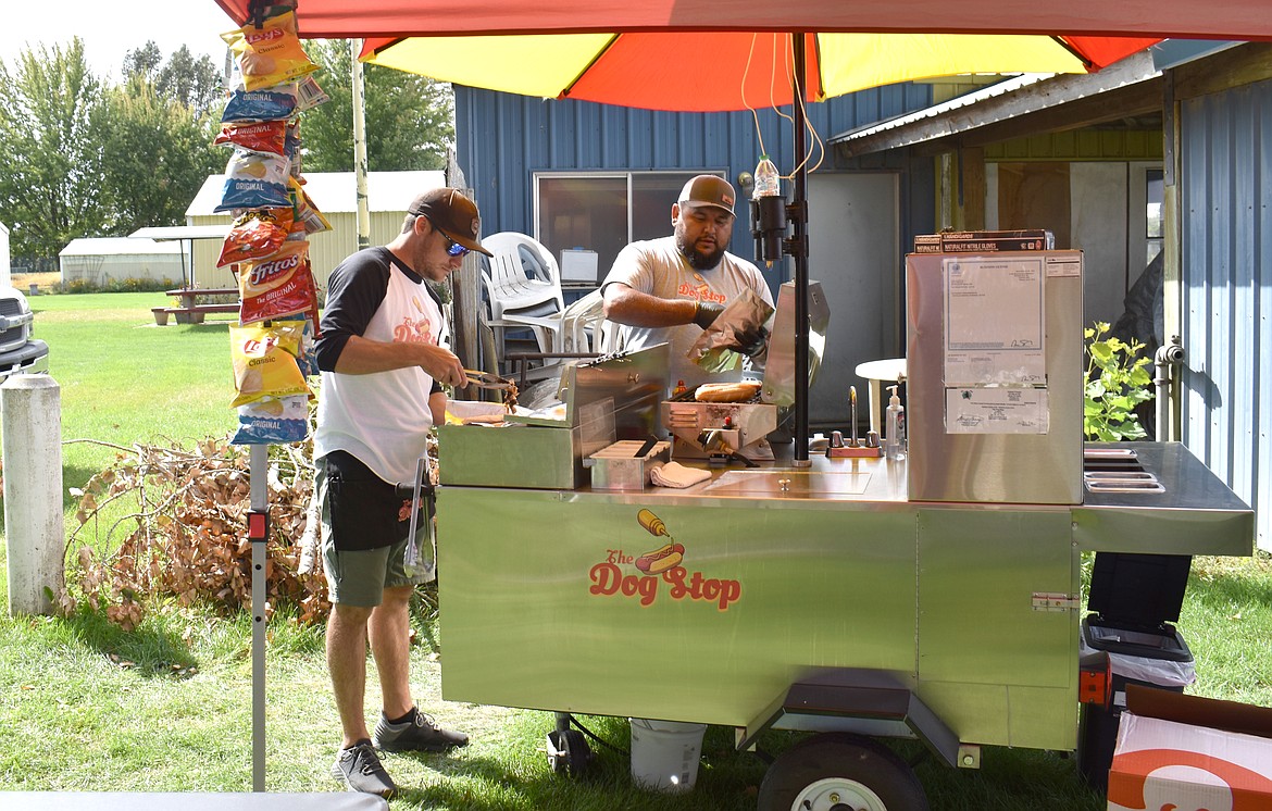 Jacob Schultz, left, and his brother-in-law Antonio Najera serve up gourmet hot dogs from their truck The Dog Stop at RitzFest Saturday.