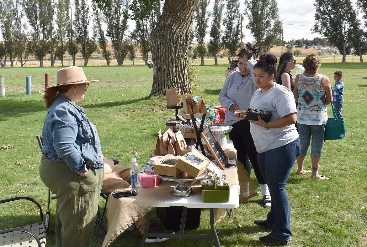 Stephanie Sanchez, right, and Melody Glass look over the goodies on offer from Sweet Treats Bakery while owner Monique Curtis looks on. “My husband is diabetic,” Curtis said. “He says it’s like living with a drug dealer.”