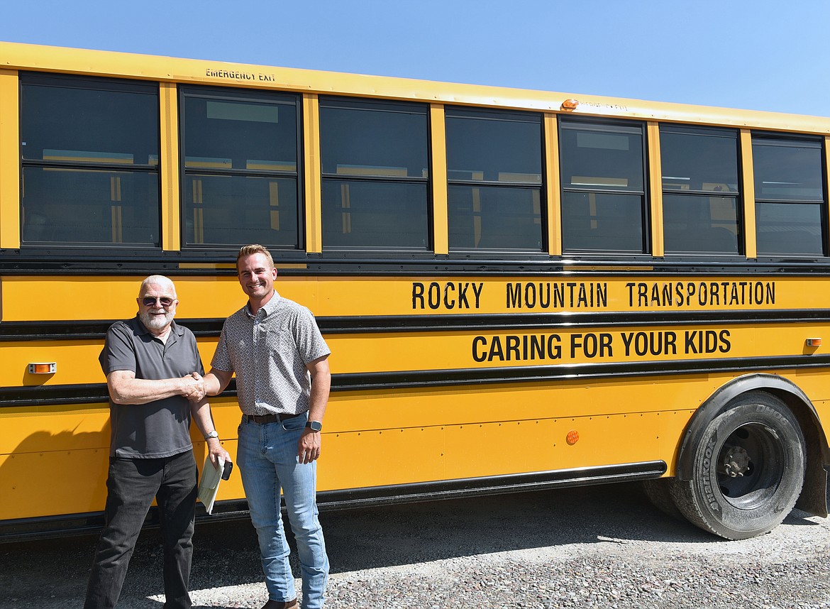 Dale Duff shakes hands with Seth Soley in honor of handing off Rocky Mountain Transportation Inc. (Kelsey Evans/Whitefish Pilot)