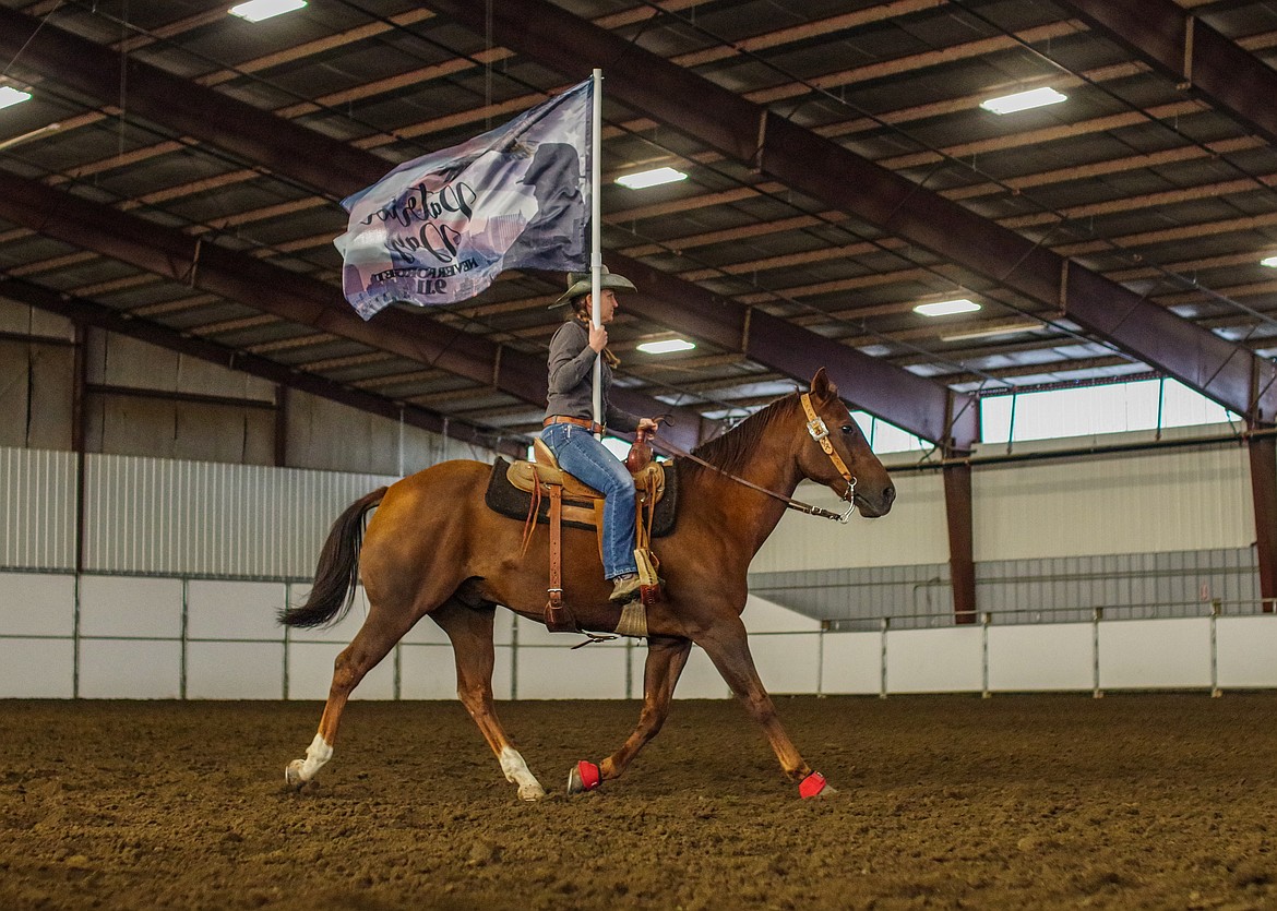 Cassie Berryman carries a Patriot Day flag at last year’s Columbia Basin Barrel Racing Club Patriot Fall Classic Race in Moses Lake.