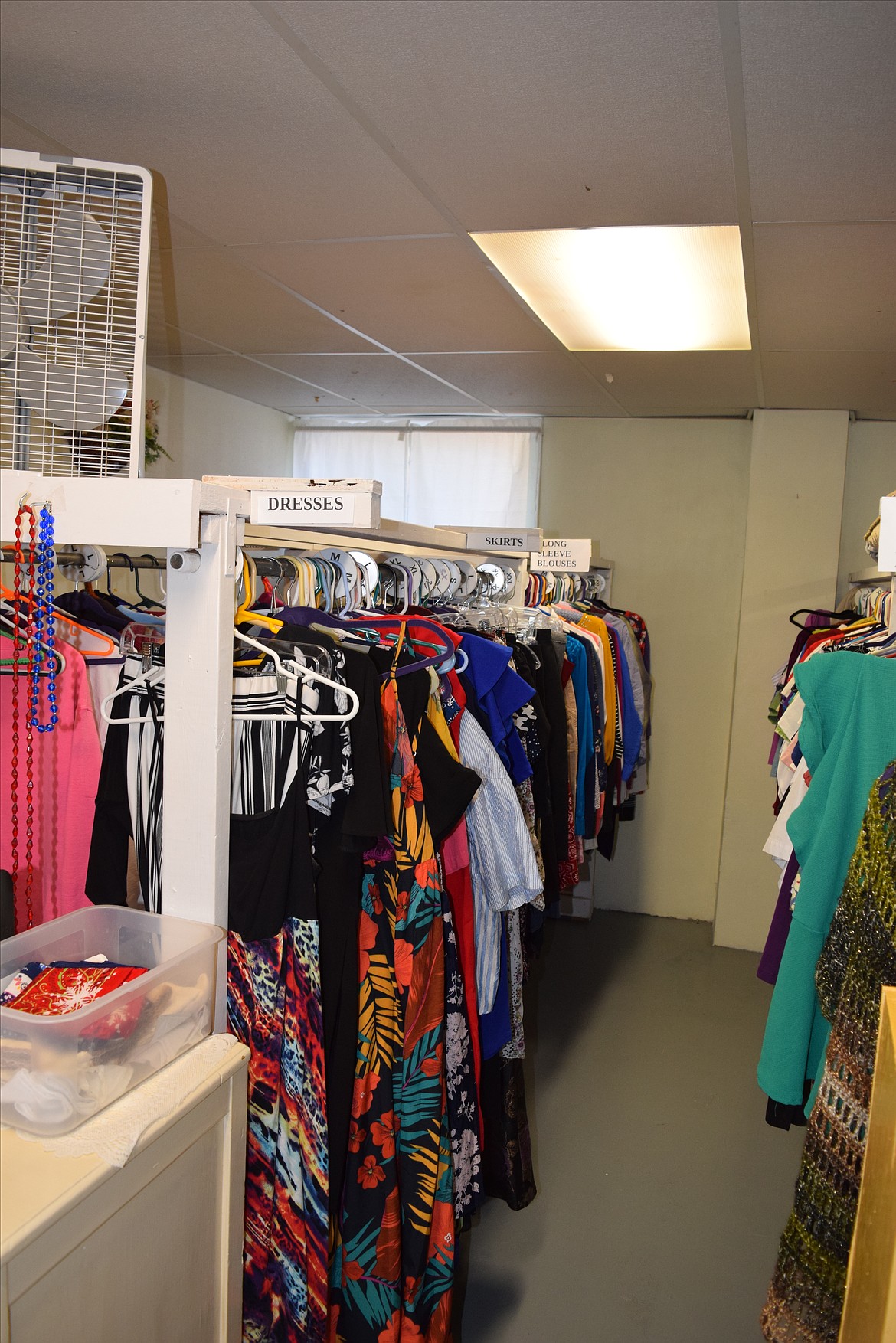 Dresses, simple jewelry and other items are available for women at the clothing bank. To the right of this display are men's items, including ties, jeans and other clothing.