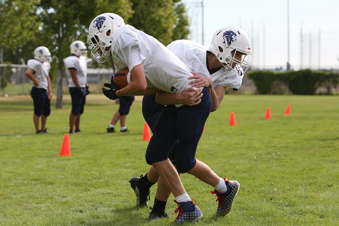 Lion players work on tackling drills during practice on Saturday.