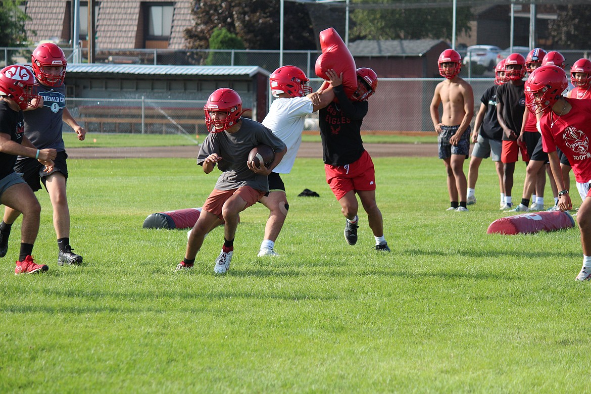 Othello defensive players work to corral the running back during practice last week.