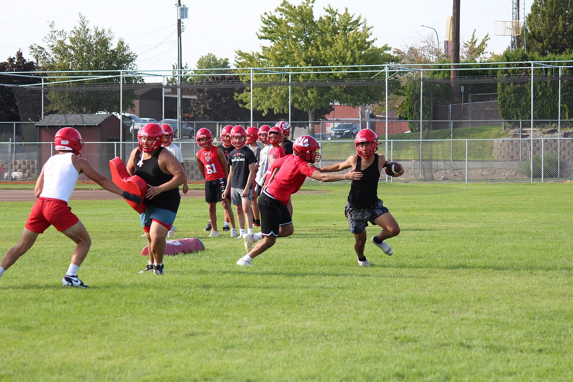 An Othello running back tries to evade the defense during the first week of practice.