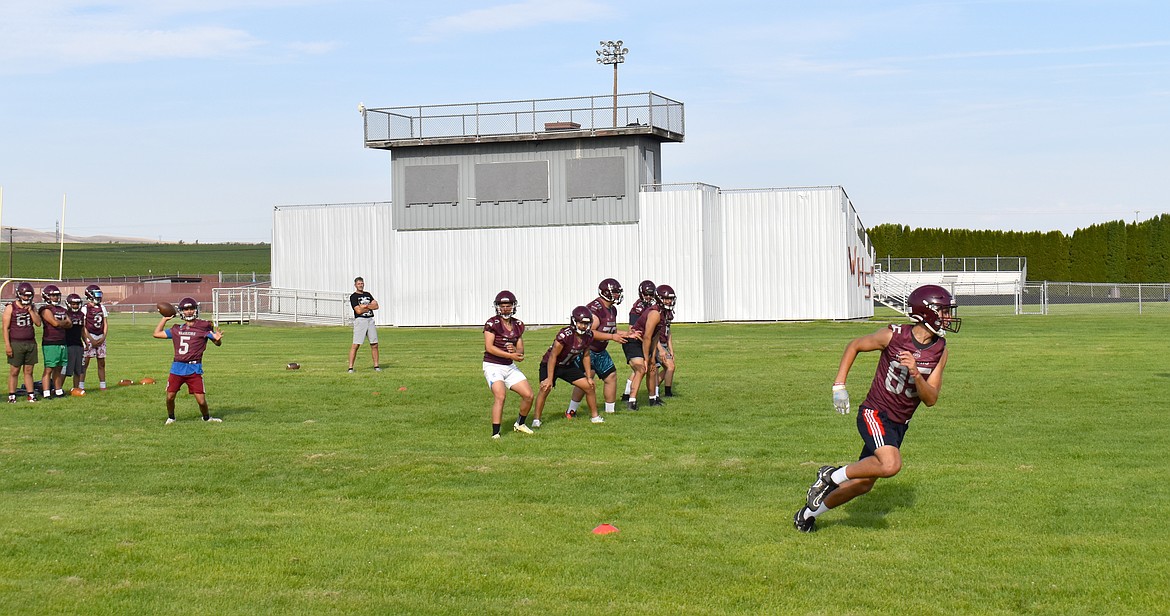 Jose Valdovinos, left, gets ready to throw to Hudson Heslop at the Wahluke Warriors football practice Aug. 22.