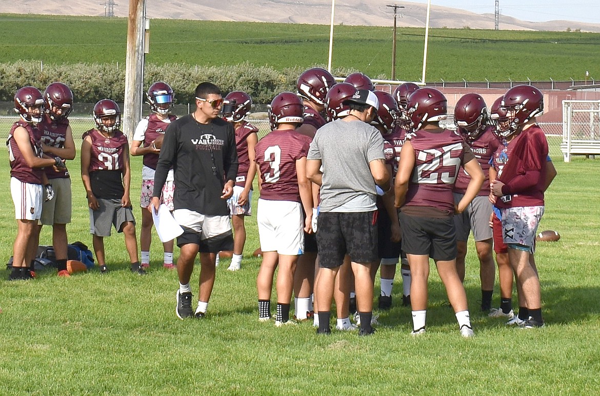 Head Coach Anfernee Cortez, in black, addresses some of his players in a huddle. This year’s Warriors are a young team, he said, with lots to learn.