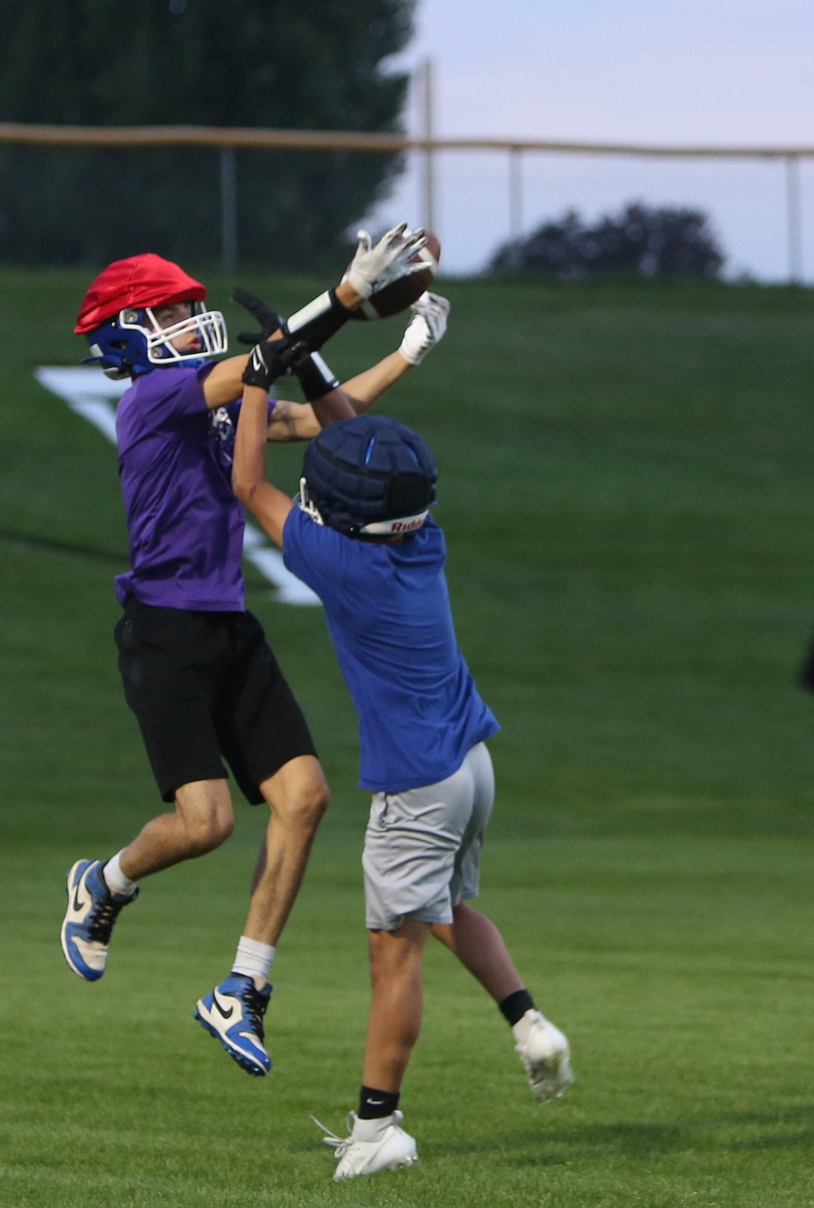 Warden senior Michael Gonzalez, in purple, elevates for a reception during practice.