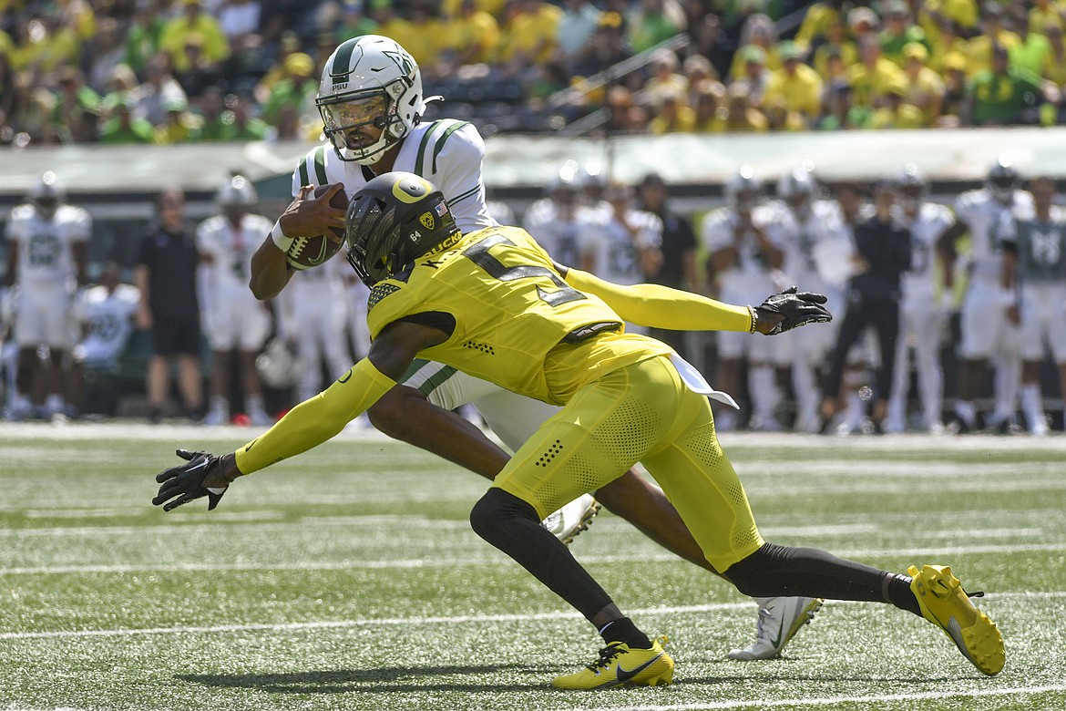 Portland State quarterback Dante Chachere, in white, looks to evade an Oregon defender during a game against the Ducks last season. Chachere, a dual-threat quarterback, is Portland State’s leading returning rusher from 2023.