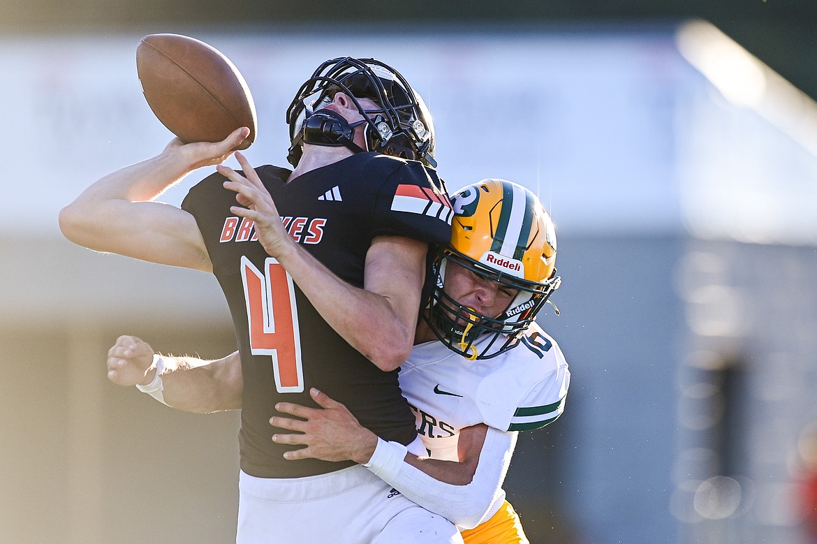 Flathead quarterback Brett Pesola (4) is hit by Great Falls CMR defender Dalton Heggem (16) at Legends Stadium on Friday, Aug. 30. (Casey Kreider/Daily Inter Lake)