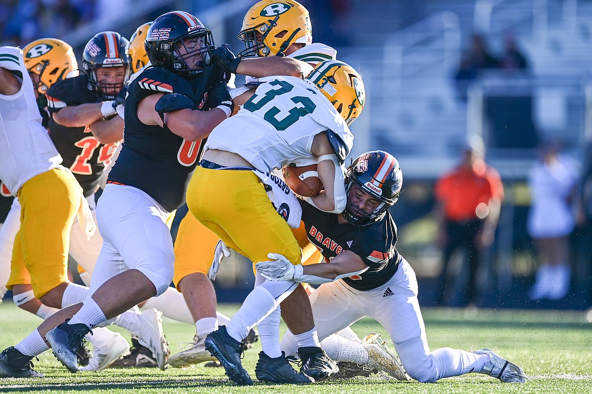 Flathead defenders Brayton Fitch (30) and Jakob Berry (65) stop a run by Great Falls CMR running back Keegan Fuller (33) in the first quarter at Legends Stadium on Friday, Aug. 30. (Casey Kreider/Daily Inter Lake)