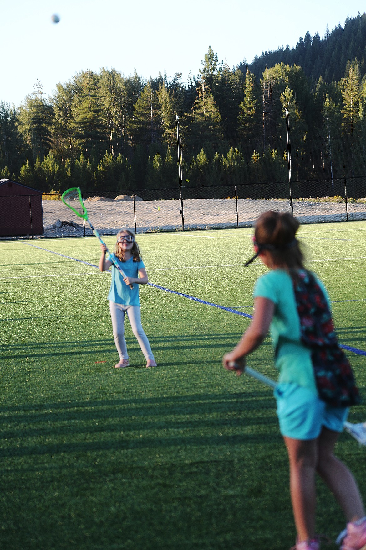 Two youths practice their lacrosse skills at the grand opening of the Field of Dreams.