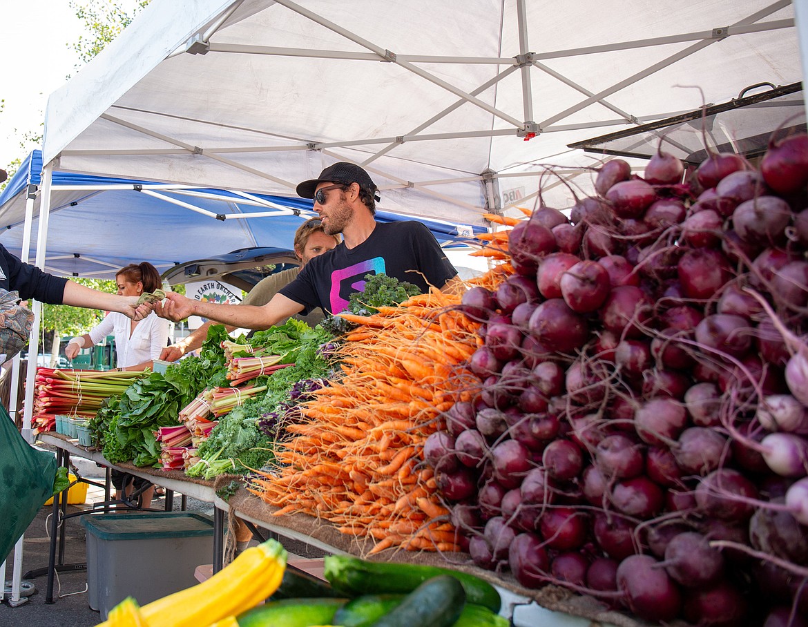 Grant Marcuccio sells produce at the Whitefish Farmer's Market July 30. (Andrea Getts Photo)