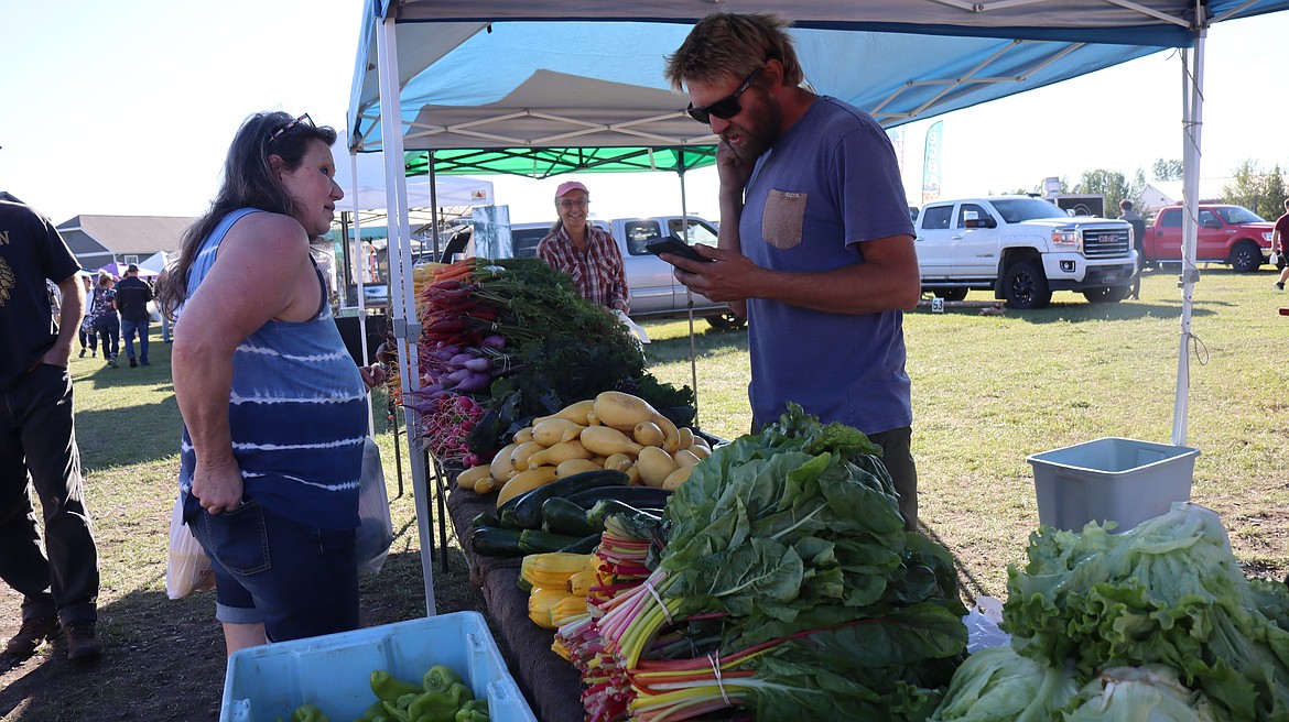 WhiteStar Organics Owner Chris Bickford sells vegetables at the Columbia Falls Community Market on Aug. 29, 2024. (Taylor Inman/Daily Inter Lake)