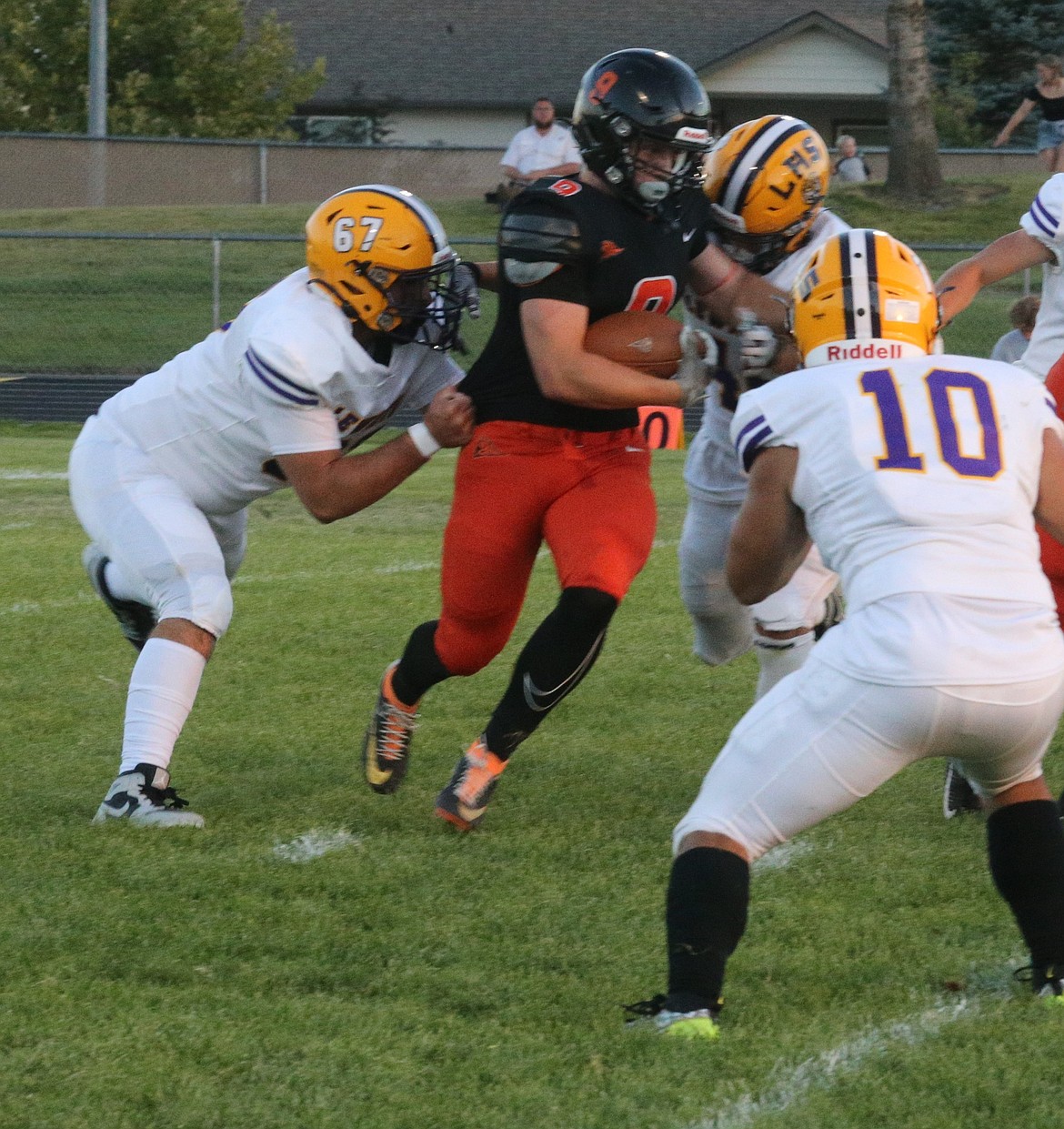 JASON ELLIOTT/Press
Post Falls senior running back Devin Burton fights out of the hands of Lewiston defensive lineman Lucas West during the first quarter of Friday's game at Trojan Stadium.