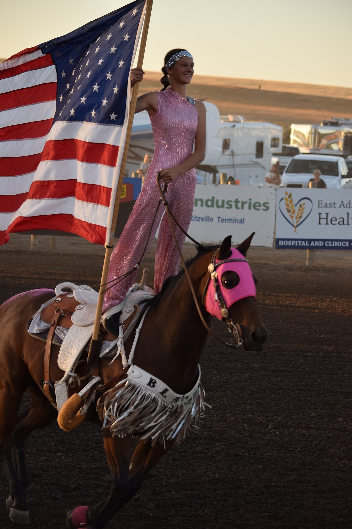 One of the Wild Card Trick Riders stands on her horse as she presents the American Flag during the National Anthem at the Ritzville Rodeo on Aug. 30.