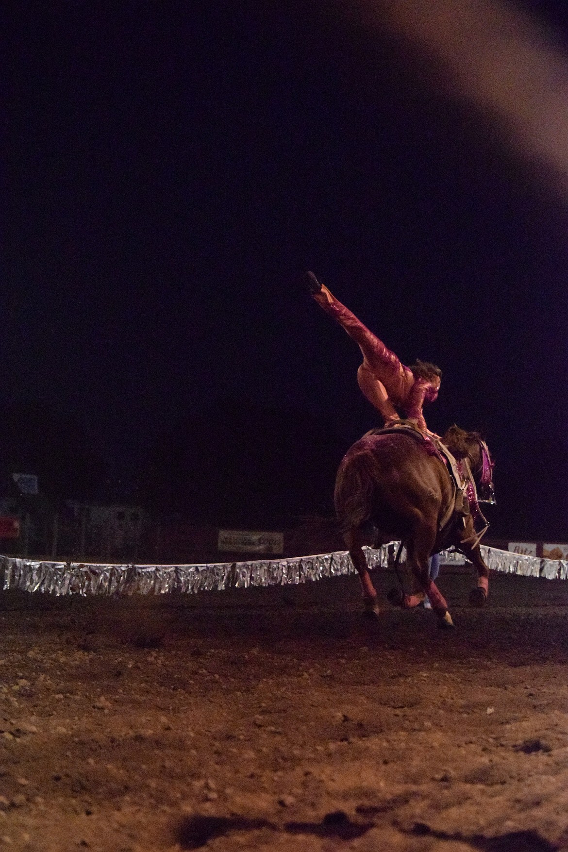 One of the Wild Card Trick Riders stands on her horse during the team’s performance. There are four young women ranging from 11 to 15 years old.