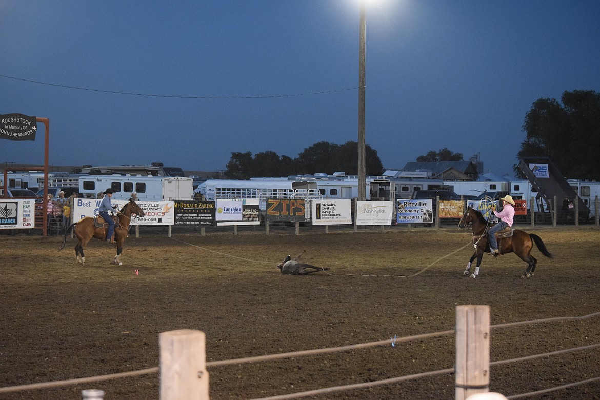 A cowboy and cowgirl qualify for team roping at the Ritzville Rodeo on Aug. 30. Team roping requires a pair to catch the head of a calf and the back legs.