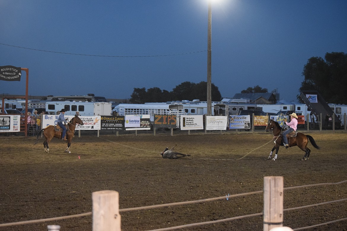 A cowboy and cowgirl qualify for team roping at the Ritzville Rodeo on Aug. 30. Team roping requires a pair to catch the head of a calf and the back legs.