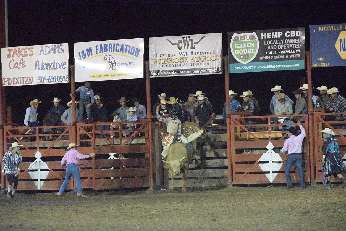 A cowboy tries to ride a bull at the Ritzville rodeo Aug. 30. There were no qualifying bull riders at Friday night’s rodeo.