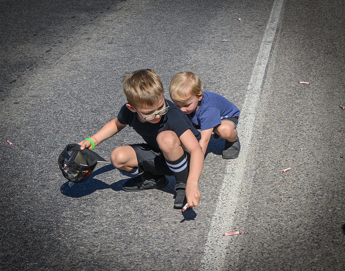 Two- year-old Brooks and_Jeremiah_Humphery, 6, fill a hat with candy during the parade. (Tracy Scott/Valley Press)