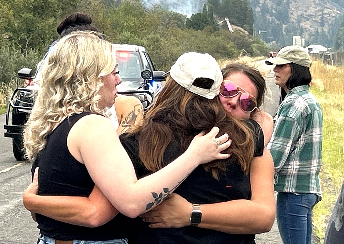 Wolf Lodge employees hug on Frontage Road just west of the restaurant on Monday.