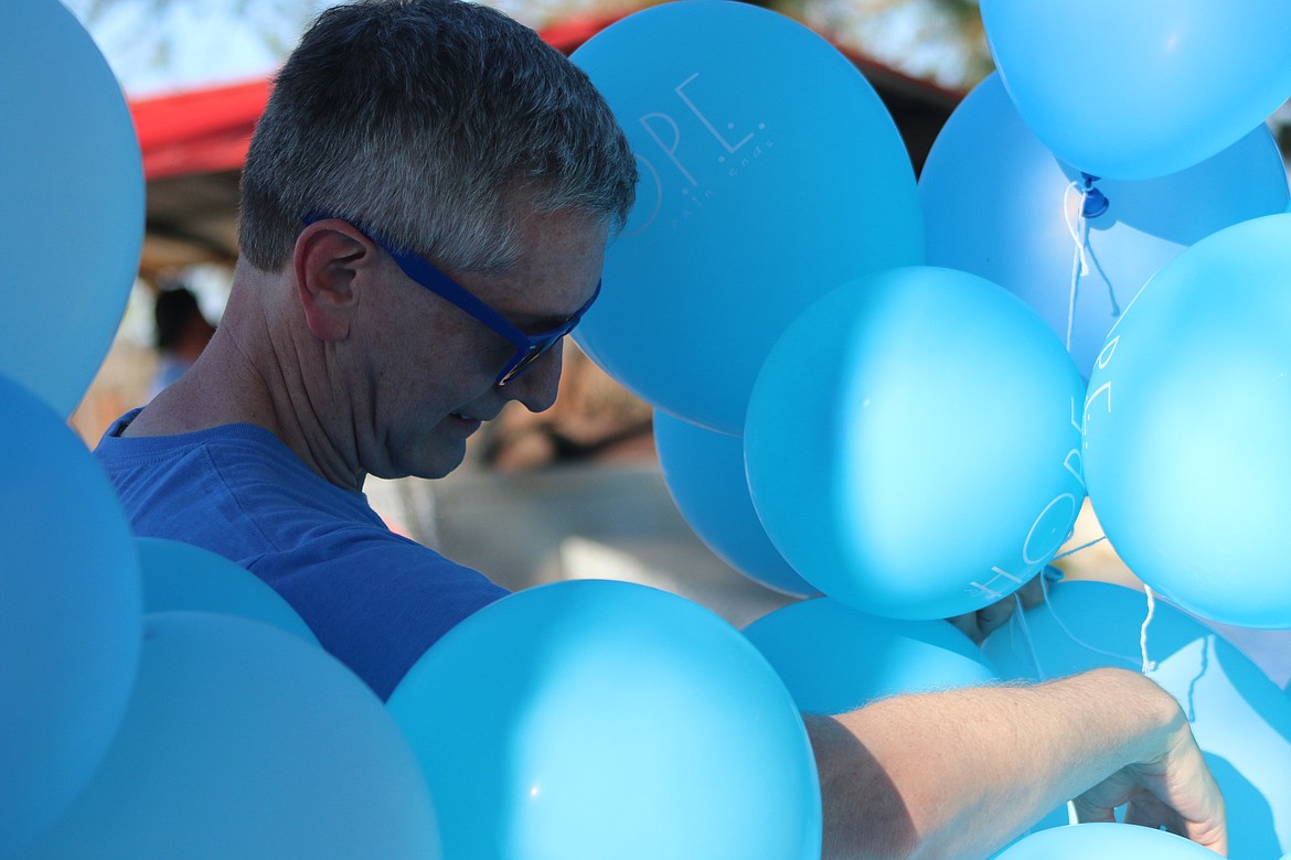 A Walk for HOPE volunteers gets balloons ready to hand out during Sunday's Walk for HOPE>