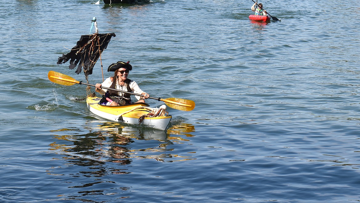 Linda Rosenow of Moses Lake paddles her boat, the Sleazy Mermaid, across the finish line in the Pirate Regatta at Camas Cove Cellars Sunday.