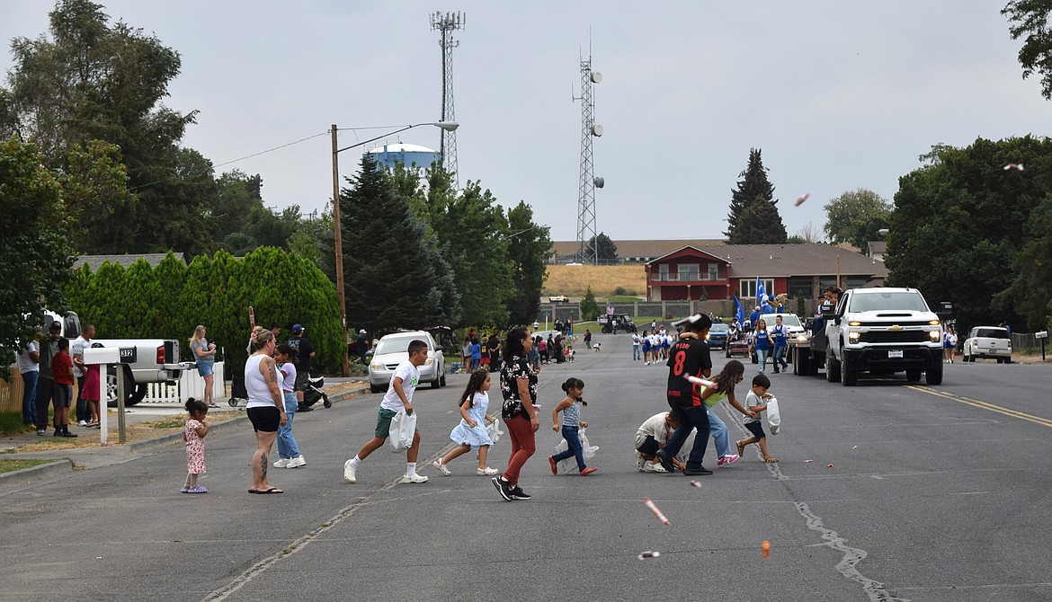 People go out into the middle of the street to gather thrown candy at the Warden Community Days parade.