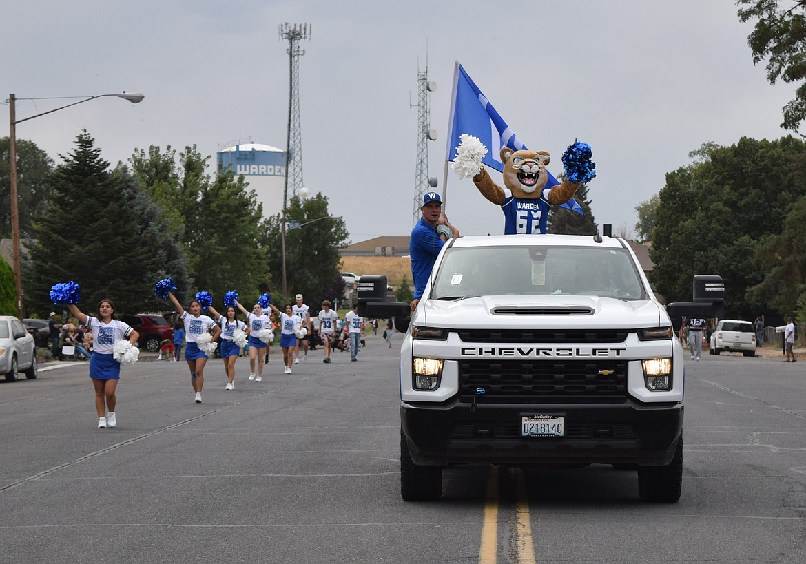 The Warden High School mascot, the Cougar, cheers in the back of a flatbed truck Monday during the Warden Community Day parade.