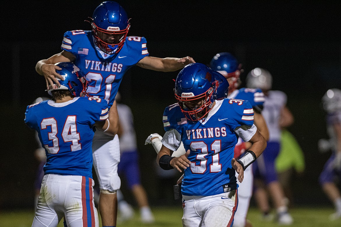 Dane Carlsen, Quinn Kerr and Austin Savik celebrate a Bigfork touchdown Friday. (Avery Howe/Bigfork Eagle)